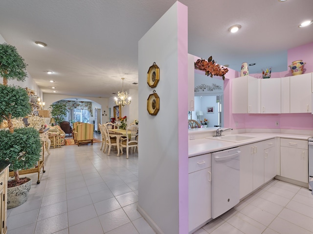 kitchen with a notable chandelier, white appliances, a sink, white cabinets, and light countertops