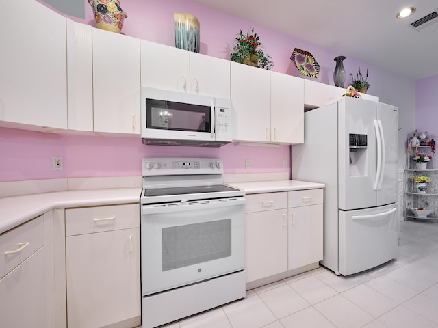 kitchen with light tile patterned floors, white appliances, visible vents, white cabinetry, and light countertops