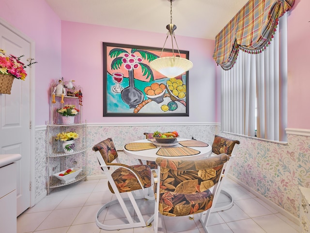 dining space with wainscoting and tile patterned flooring