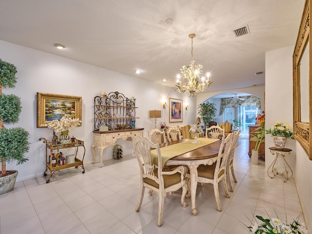 dining space with arched walkways, light tile patterned flooring, a chandelier, and visible vents