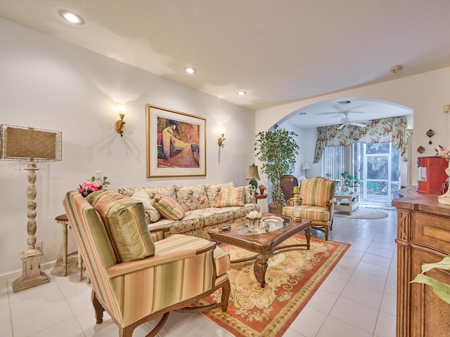 living room featuring arched walkways, recessed lighting, a ceiling fan, light tile patterned flooring, and a textured ceiling