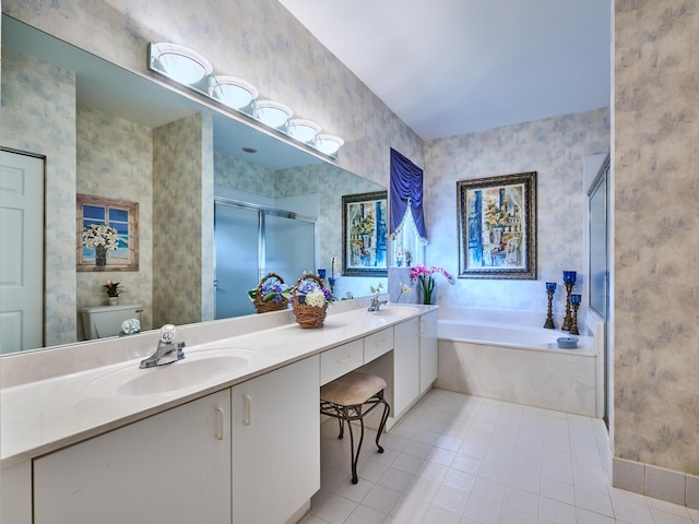 bathroom with a garden tub, a sink, double vanity, a stall shower, and wallpapered walls