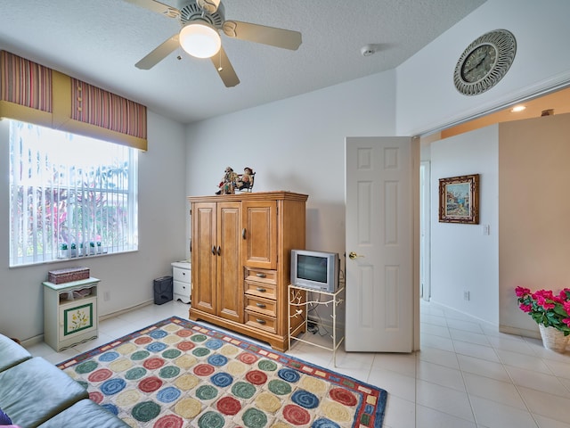 sitting room featuring light tile patterned floors, ceiling fan, vaulted ceiling, and a textured ceiling