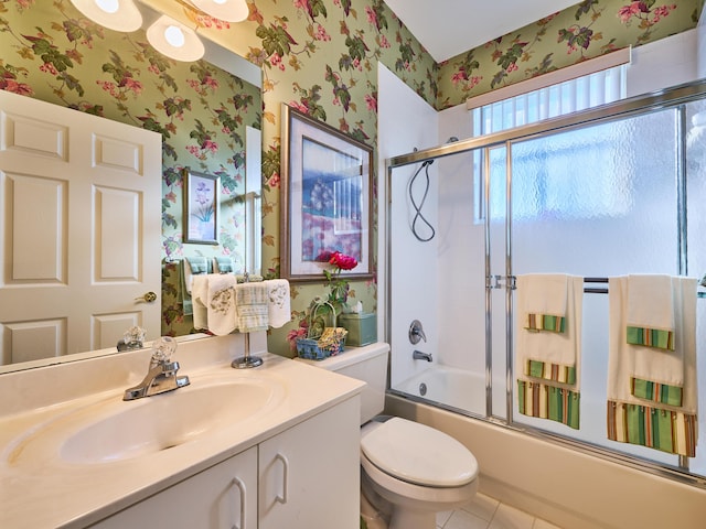 bathroom with tile patterned flooring, toilet, vanity, combined bath / shower with glass door, and wallpapered walls