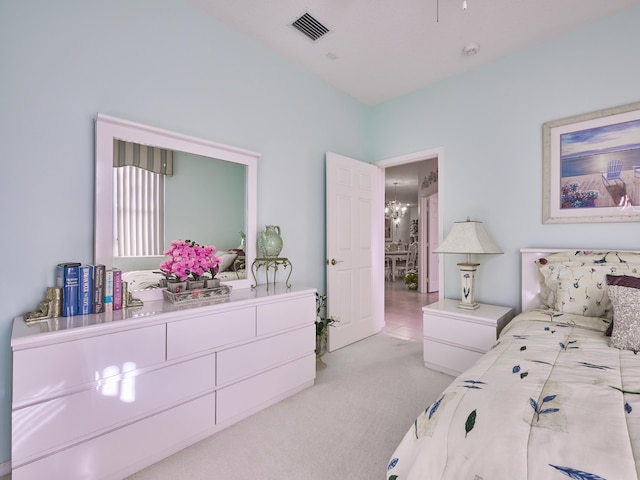 bedroom with carpet floors, visible vents, and an inviting chandelier