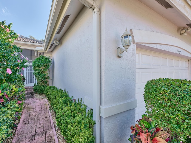 view of side of home featuring a garage and stucco siding