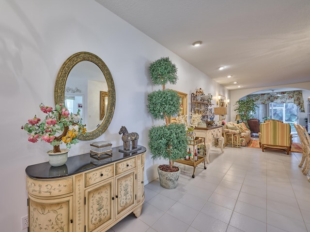 interior space featuring arched walkways and light tile patterned flooring