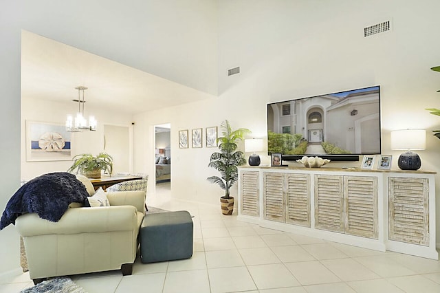 tiled living area with a high ceiling, visible vents, and a chandelier