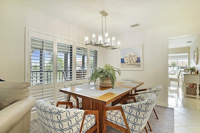 dining area featuring a chandelier, visible vents, baseboards, and light tile patterned floors