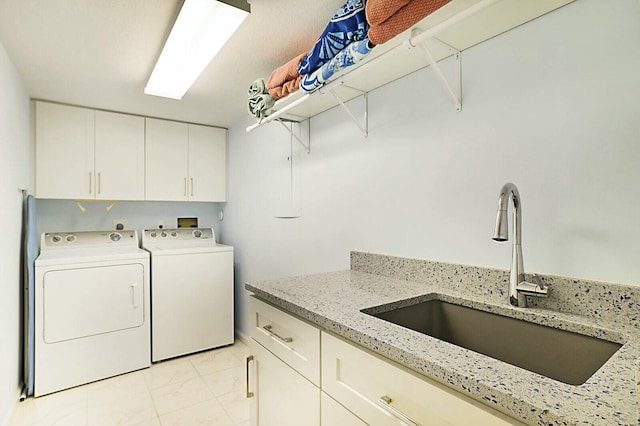 laundry room featuring washer and clothes dryer, a sink, and cabinet space