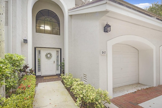 doorway to property featuring stucco siding