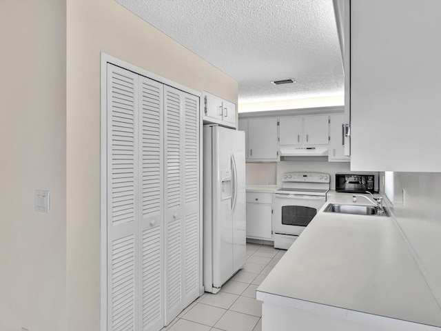 kitchen with visible vents, under cabinet range hood, light tile patterned floors, white appliances, and a sink