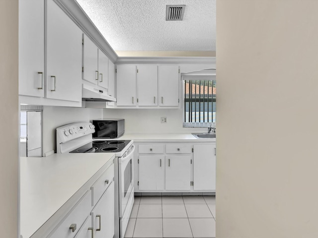 kitchen with light tile patterned floors, light countertops, electric stove, under cabinet range hood, and a textured ceiling