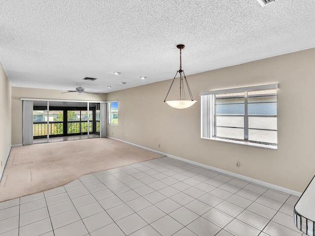 empty room featuring baseboards, a ceiling fan, visible vents, and light carpet