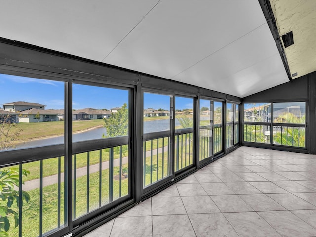 unfurnished sunroom with vaulted ceiling and a water view