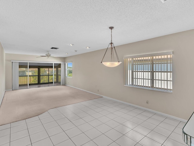 spare room with visible vents, light colored carpet, baseboards, and ceiling fan