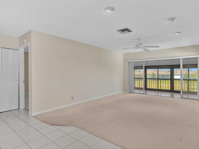 empty room featuring light carpet, visible vents, ceiling fan, and baseboards