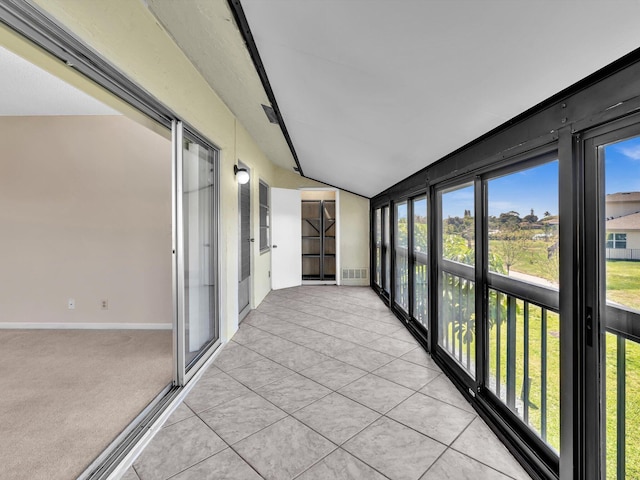 unfurnished sunroom with visible vents and vaulted ceiling