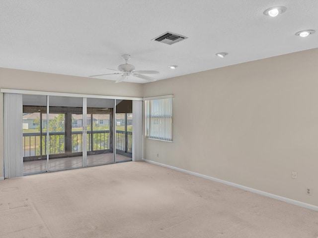 unfurnished room with visible vents, baseboards, carpet, and a ceiling fan