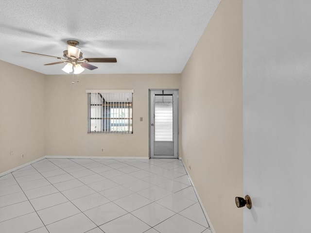 unfurnished room featuring light tile patterned floors, baseboards, a textured ceiling, and ceiling fan