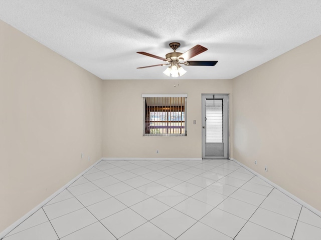 unfurnished room with baseboards, a textured ceiling, a ceiling fan, and light tile patterned flooring