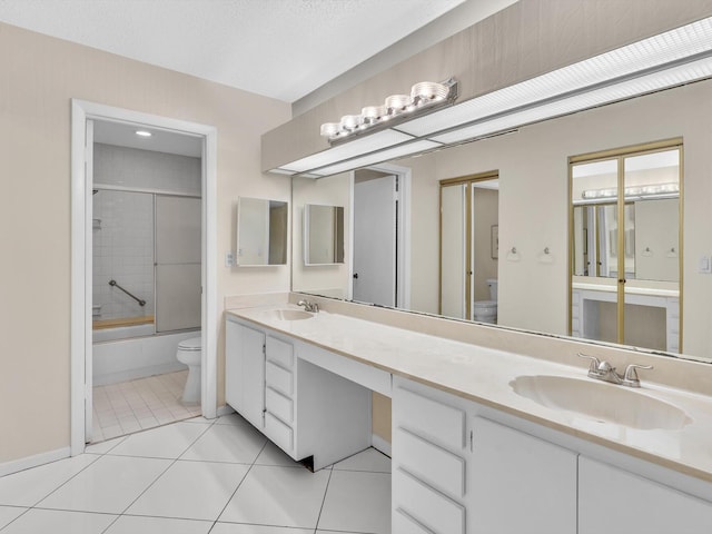 bathroom featuring tile patterned floors, a sink, toilet, and double vanity