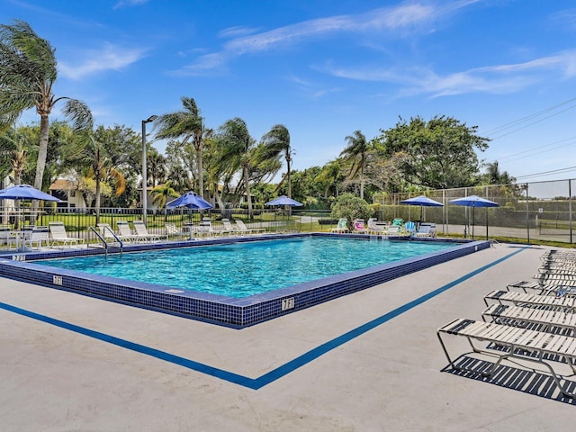 pool with a patio and fence