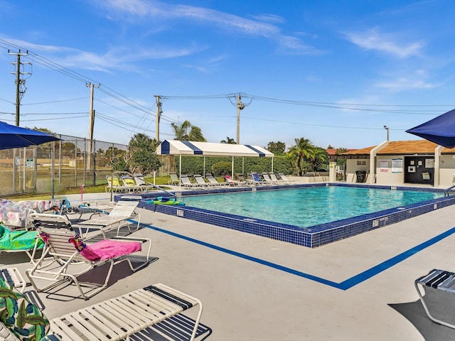 pool with a patio and fence