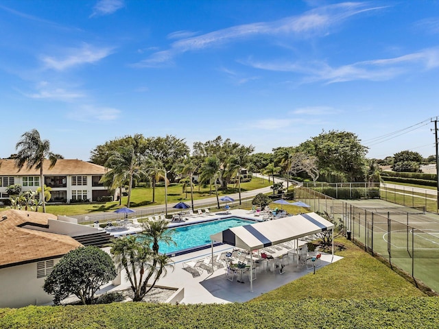 community pool featuring a patio, a yard, and fence