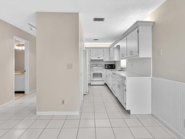 kitchen featuring light tile patterned floors, visible vents, white appliances, and light countertops