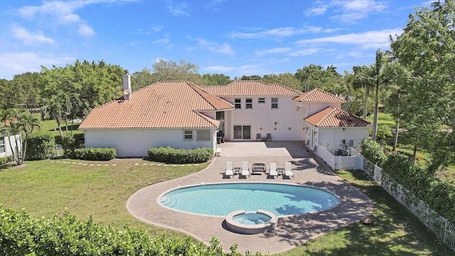 view of pool featuring a patio area, a fenced backyard, a pool with connected hot tub, and a yard