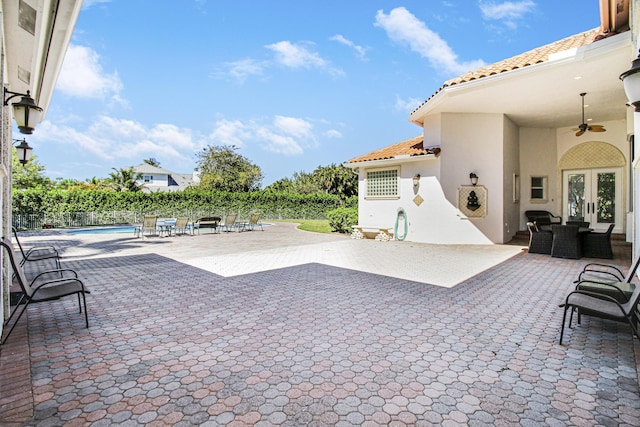 view of patio / terrace with a fenced in pool, french doors, fence, and ceiling fan