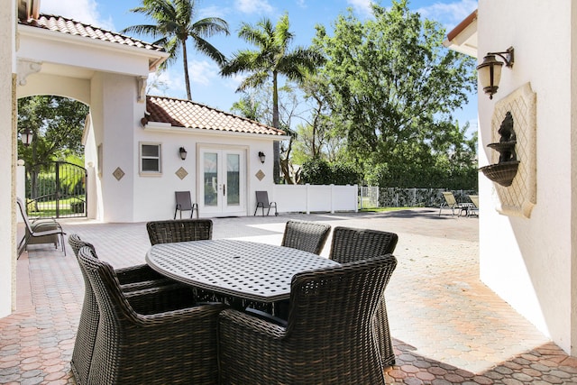 view of patio / terrace featuring french doors, outdoor dining area, and fence