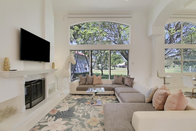 living area with a high end fireplace and a high ceiling