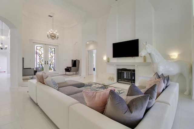 living area with arched walkways, crown molding, a high ceiling, and an inviting chandelier