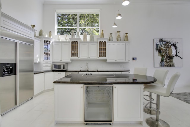 kitchen with backsplash, appliances with stainless steel finishes, glass insert cabinets, white cabinets, and beverage cooler