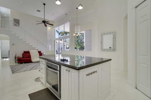 kitchen featuring black electric stovetop, oven, white cabinets, open floor plan, and a center island