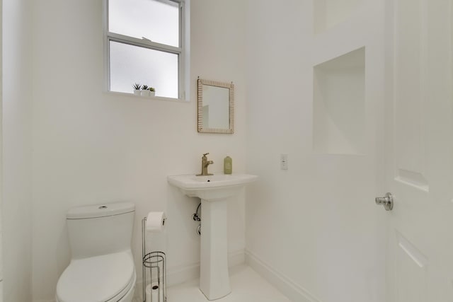 bathroom featuring baseboards and toilet