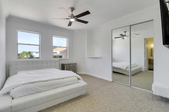 carpeted bedroom featuring baseboards, a closet, a ceiling fan, and crown molding