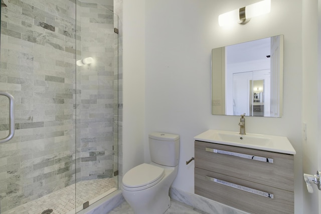 bathroom with a stall shower, vanity, and toilet