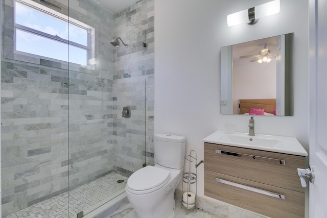 bathroom featuring toilet, a stall shower, marble finish floor, and vanity