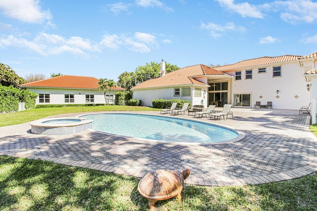 view of pool with a yard, a pool with connected hot tub, and a patio