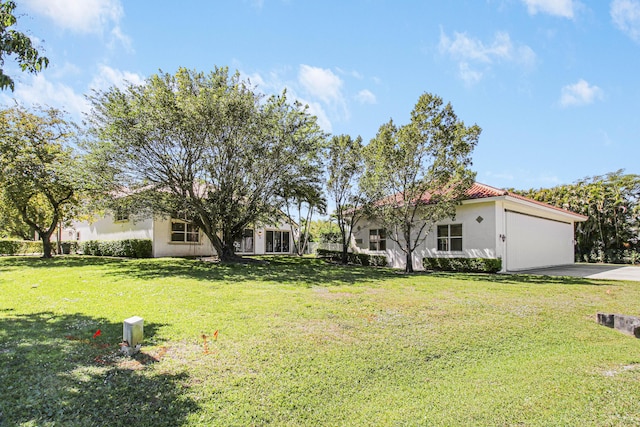 view of front of home with a garage, a tiled roof, a front lawn, and stucco siding