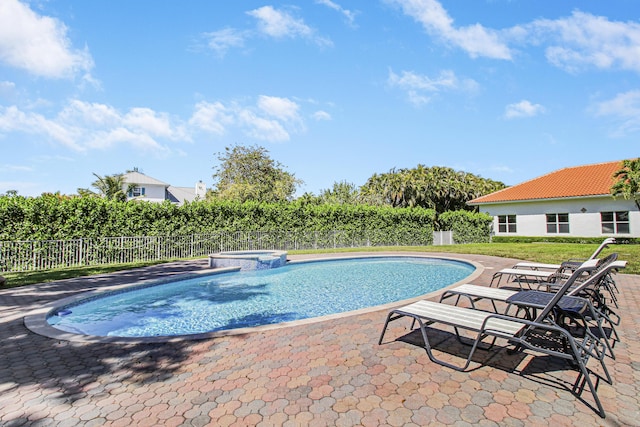 view of pool featuring a pool with connected hot tub, a patio area, and fence