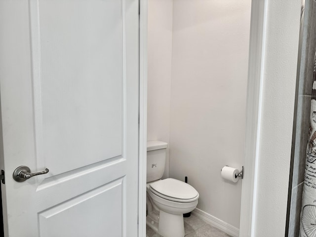 bathroom featuring baseboards, toilet, and tile patterned floors