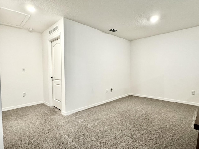 spare room with baseboards, visible vents, a textured ceiling, and carpet flooring