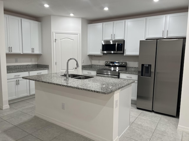 kitchen with stainless steel appliances, stone countertops, a sink, and light tile patterned flooring