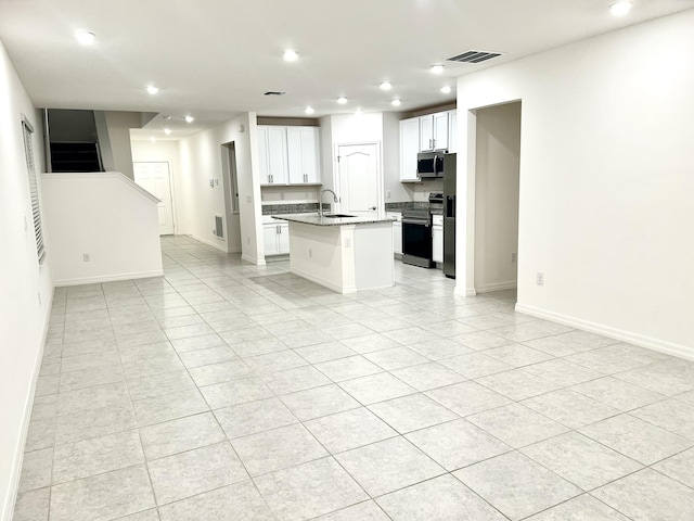 kitchen featuring a center island with sink, appliances with stainless steel finishes, open floor plan, a sink, and recessed lighting