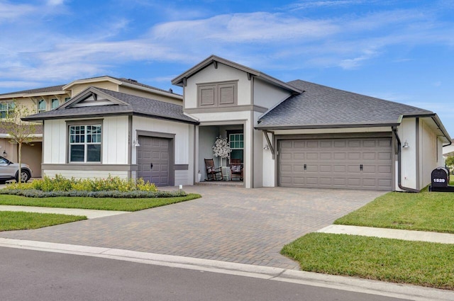 view of front facade featuring decorative driveway, an attached garage, and a shingled roof