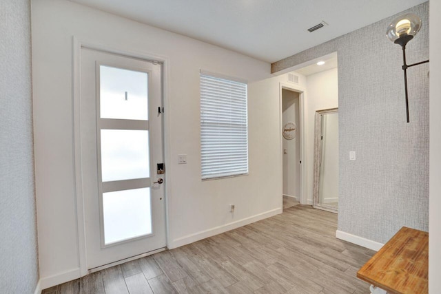 entryway with baseboards, visible vents, and light wood-type flooring